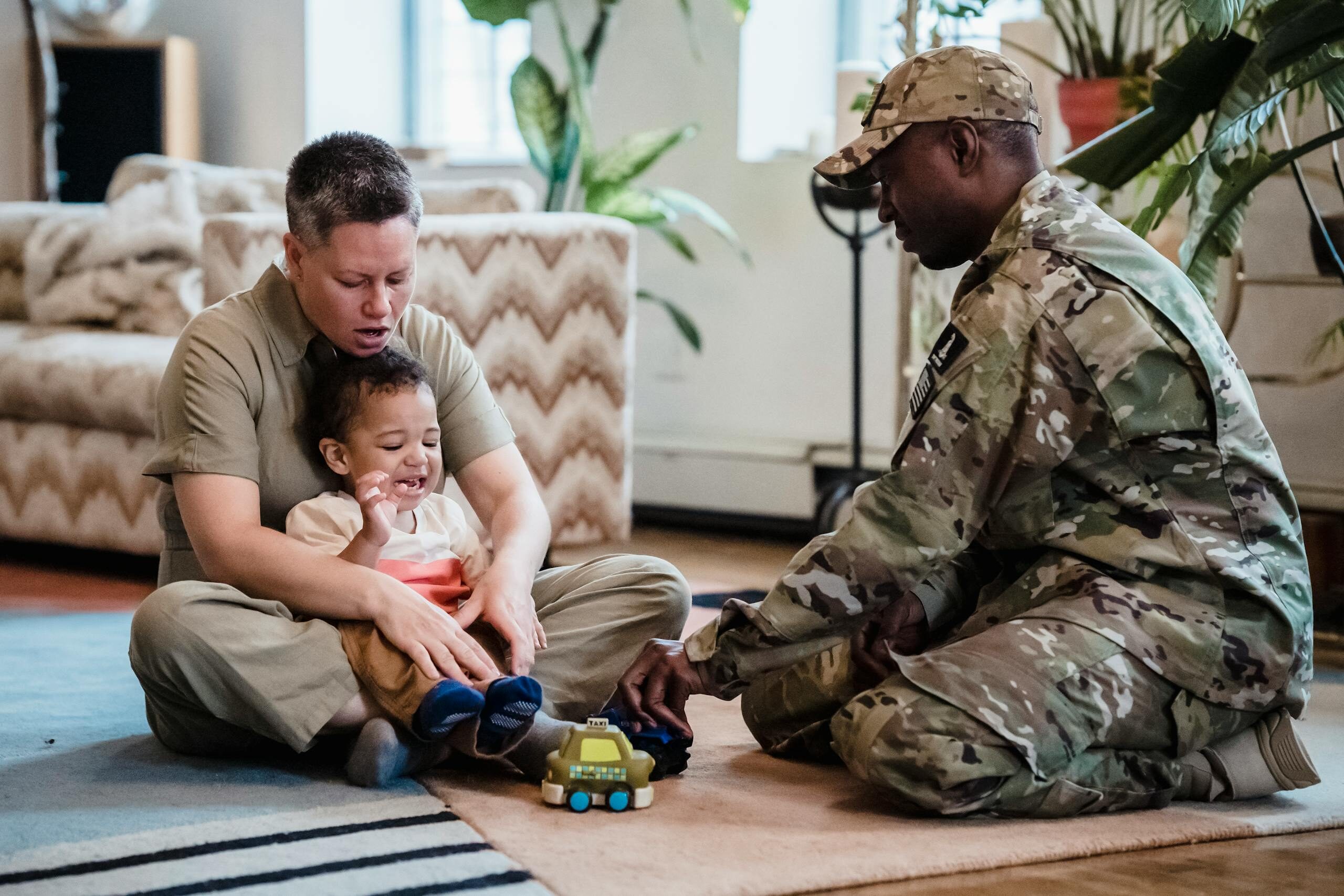 A family scene with a child playing joyfully with parents indoors, showcasing love and togetherness.